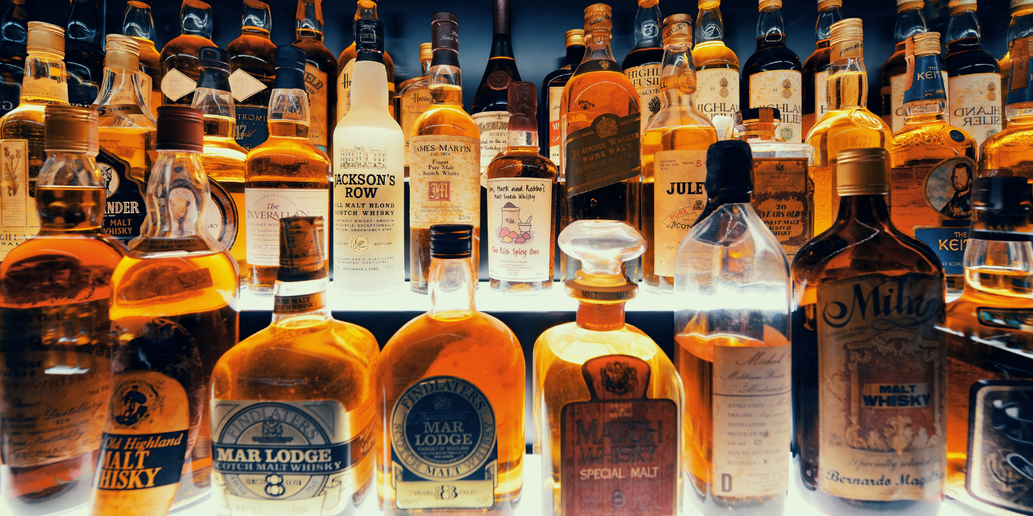 Collection of whiskey bottles on a bar shelf